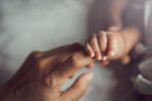 Mani di una mamma e di un neonato
