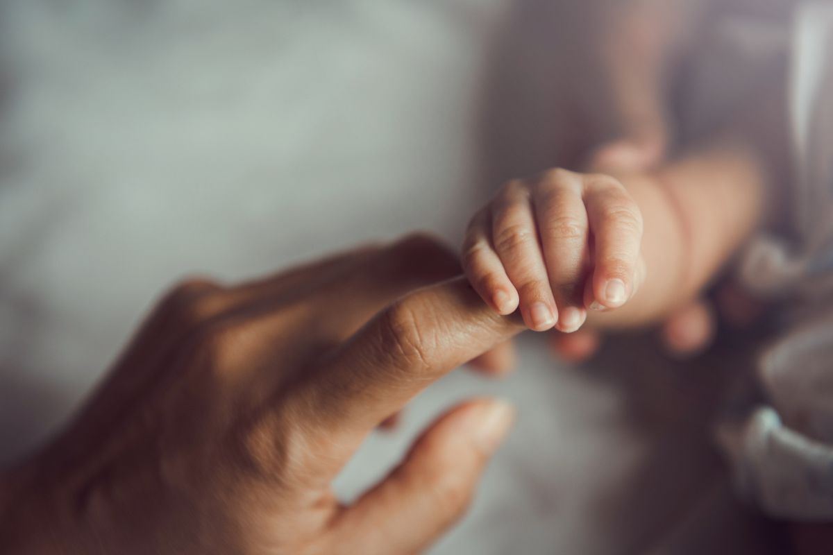 Mani di una mamma e di un neonato