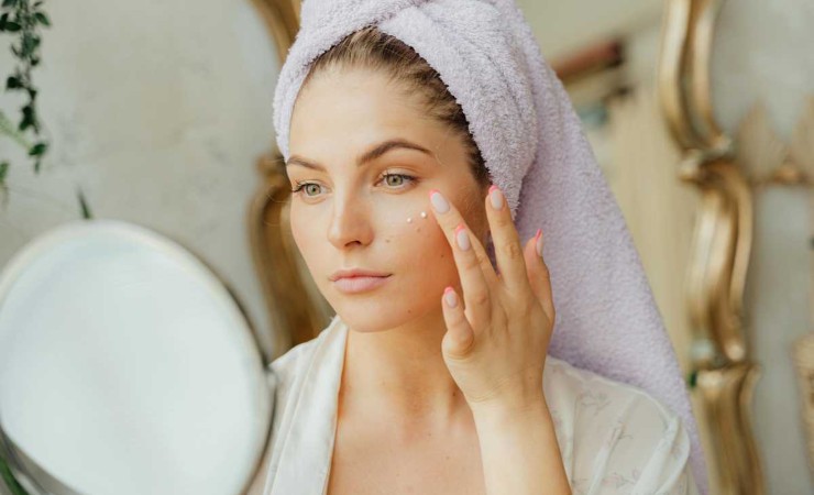 donna che mette crema sul viso