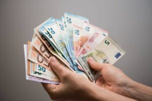 uomo che tiene in mano soldi