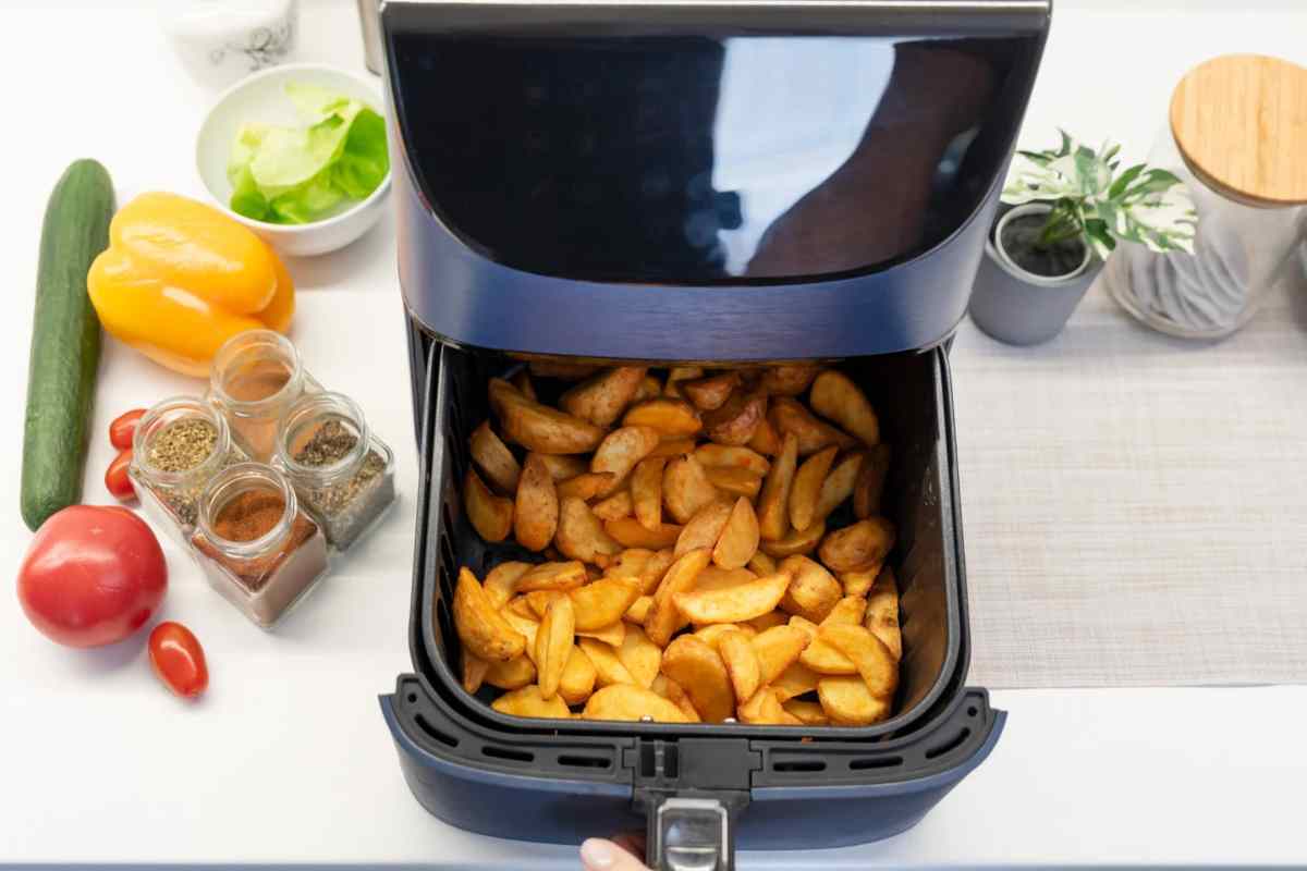Friggitrice ad aria con cestello aperto e patate dentro