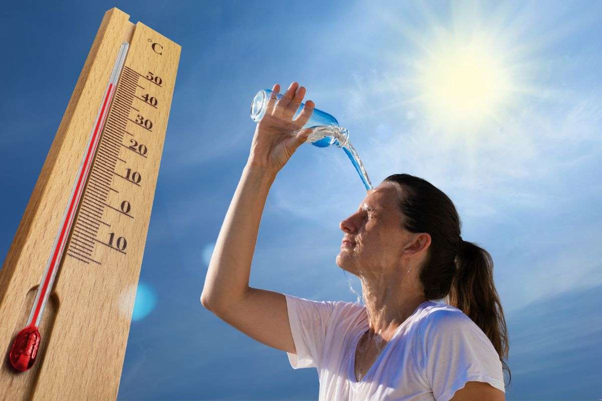 temperature alte e donna che si versa acqua in testa per il caldo