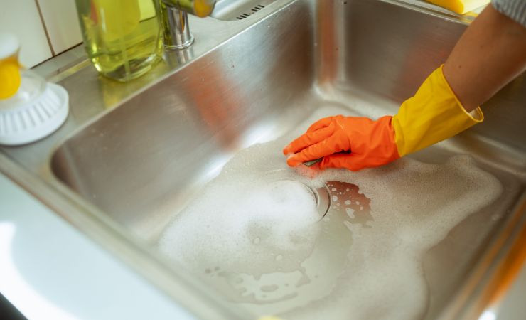 donna pulisce il lavandino della cucina