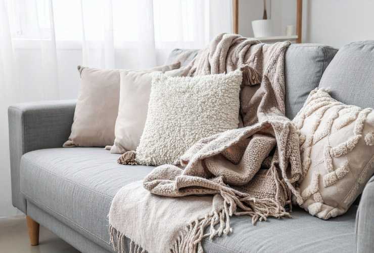 divano con coperte e cuscini