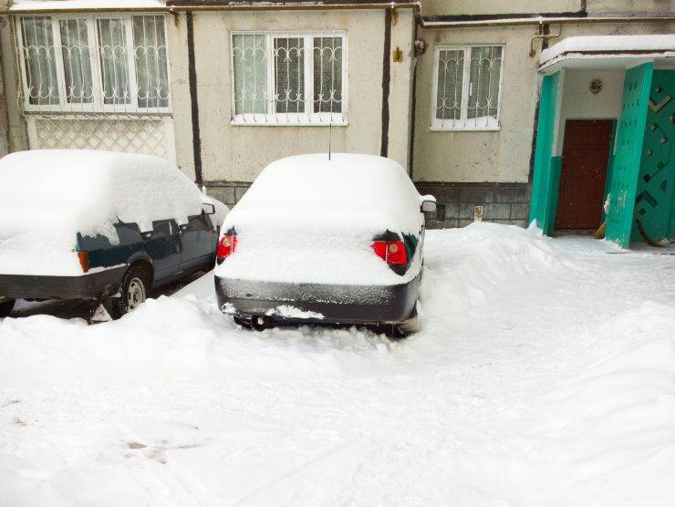 neve che ricopre macchine e strada