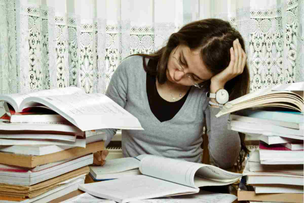 donna stanca immersa tra i libri 
