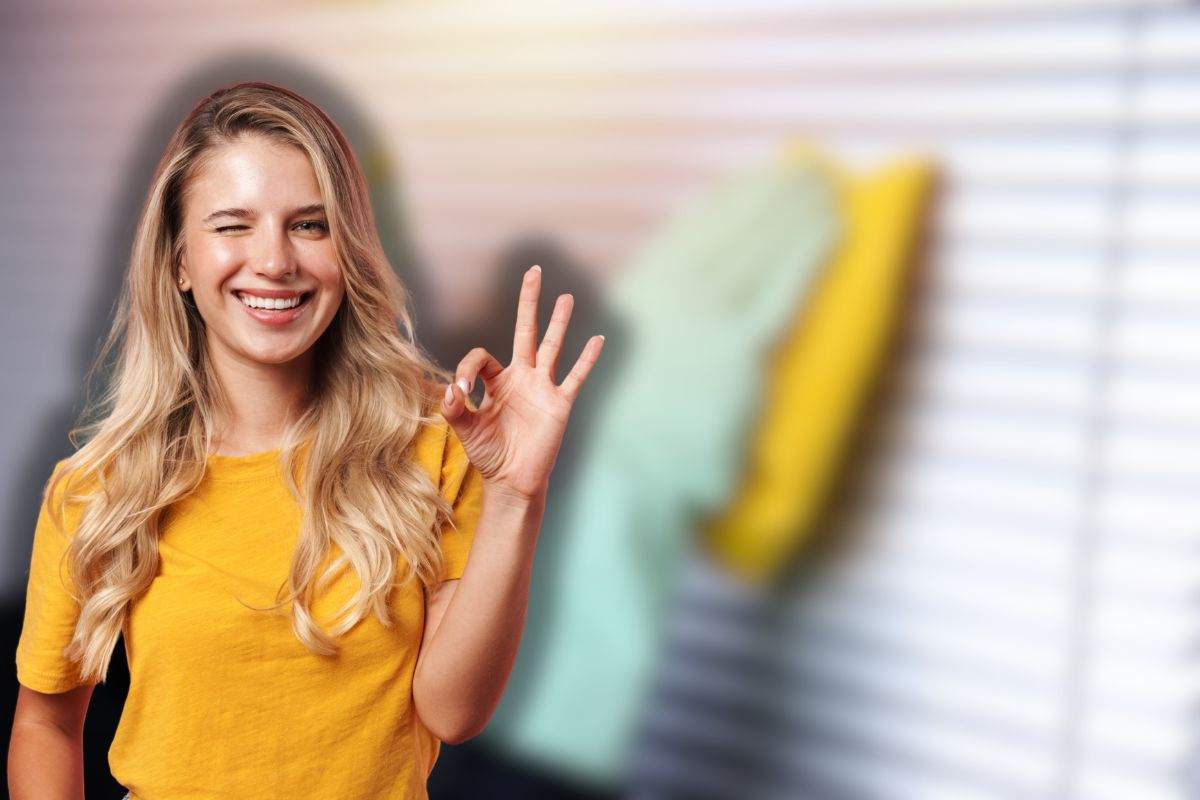 donna pulisce tapparelle e un'altra sorridente che fa ok con le mani