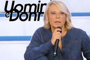 de filippi con microfono e logo uomini e donne