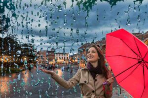 Verona sotto la pioggia e donna con ombrello che guarda la pioggia
