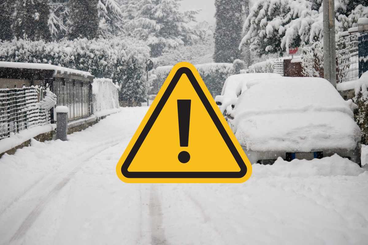 strada innevata e segnale di pericolo