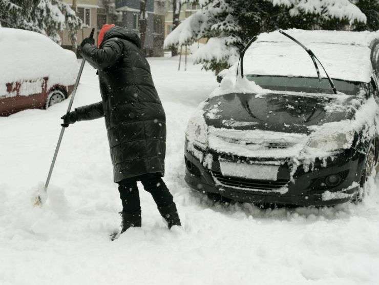 uomo che cerca di spalare la neve