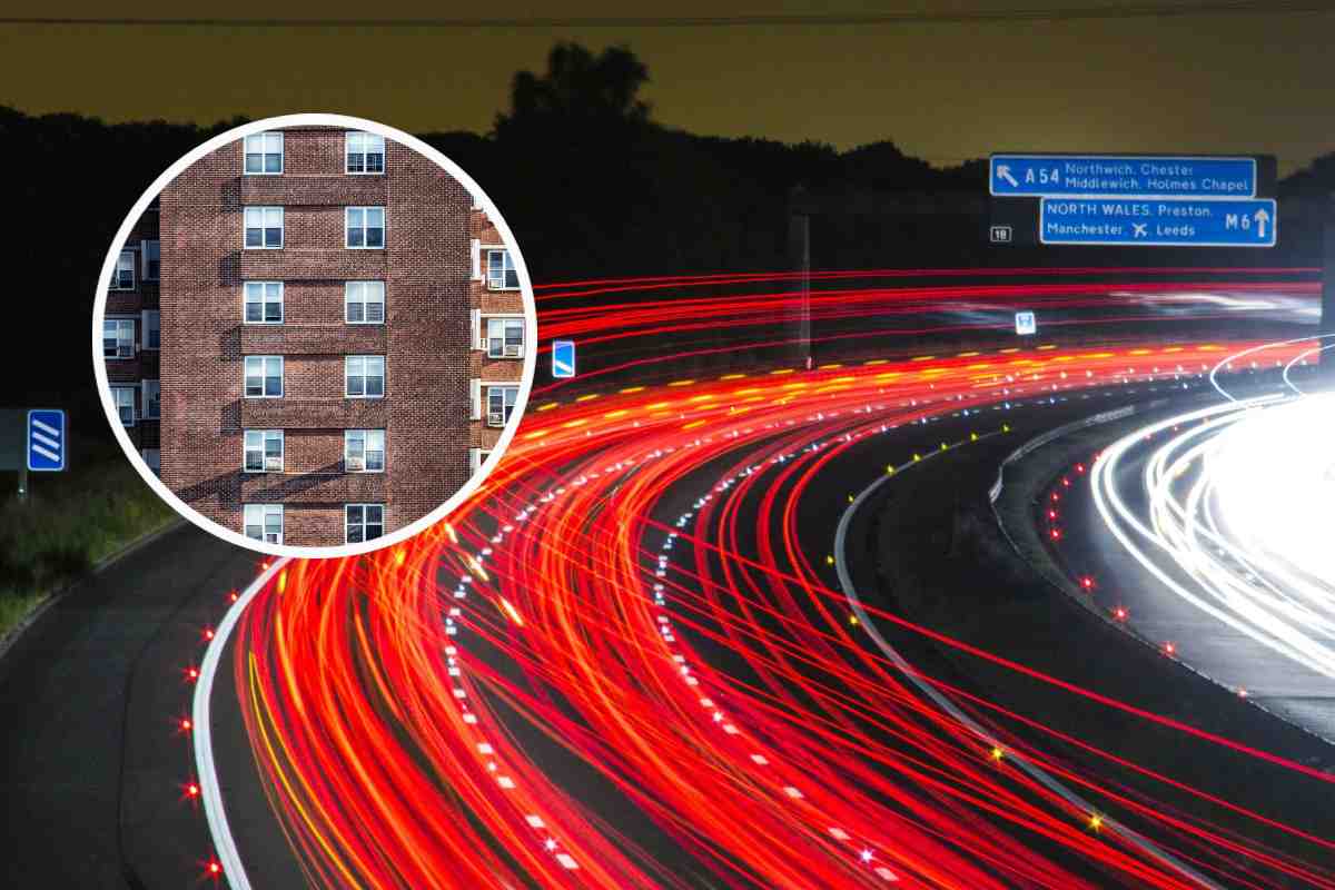 Un'autostrada fotografata dall'alto e in evidenza la facciata di un condominio marrone