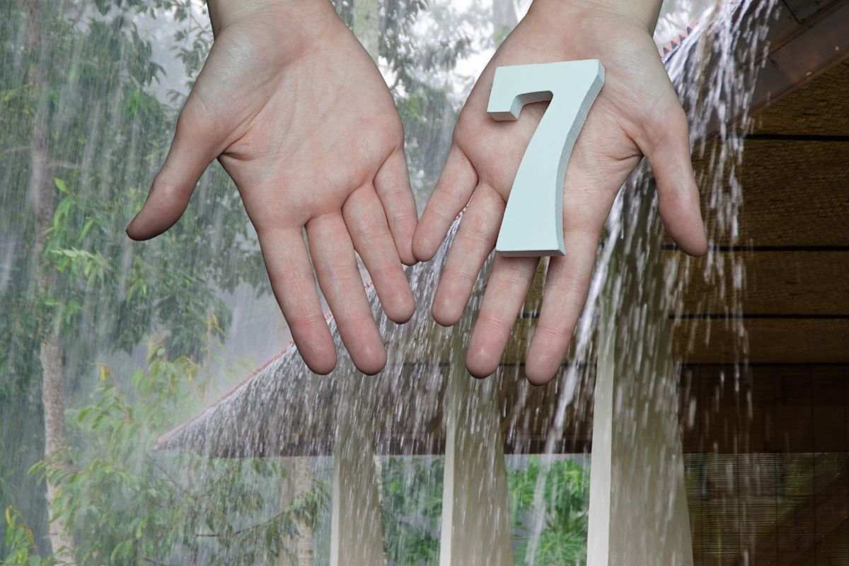 temporale e mani che hanno un numero 7 sul palmo