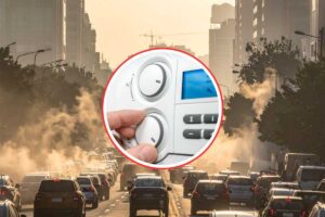 città piena di smog e mano che imposta termostato